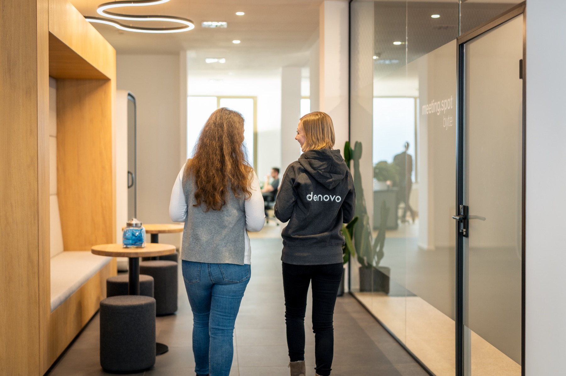 Two team members walk through the Denovo office