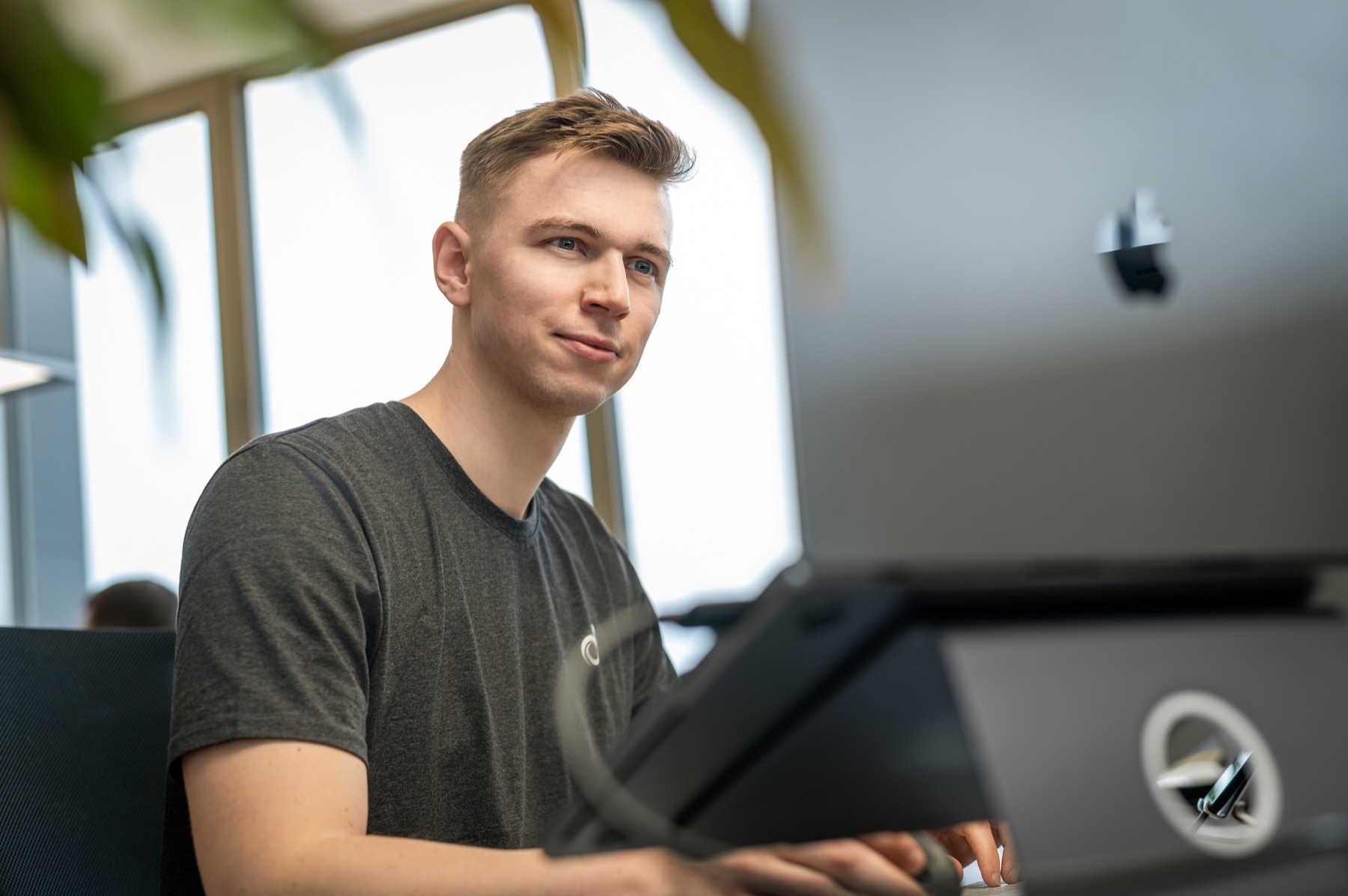 Team member works at a computer in the Denovo office