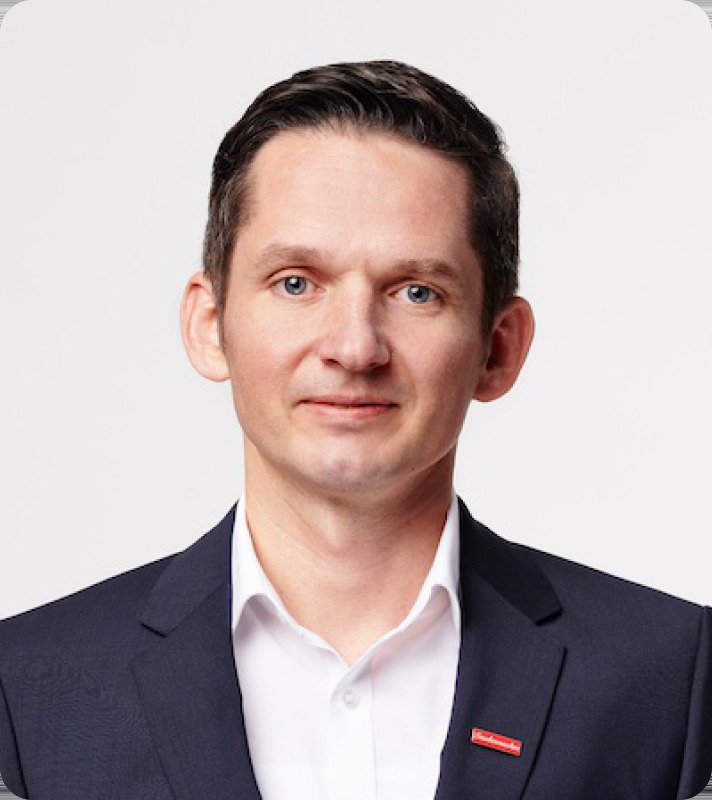 Andreas Opelt im dunklen Anzug vor einer hellen Wand